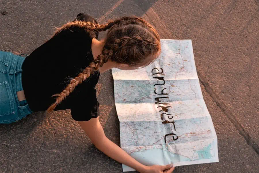 Girl reading a paper map with "anywhere" written on it