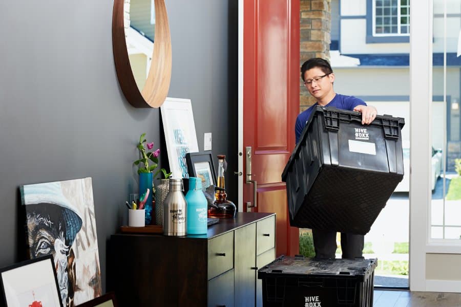 Person moving heavy boxes into their new residence