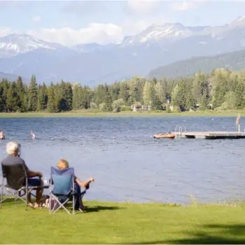 Two retired people sitting and enjoying the view of a lake in the afternoon